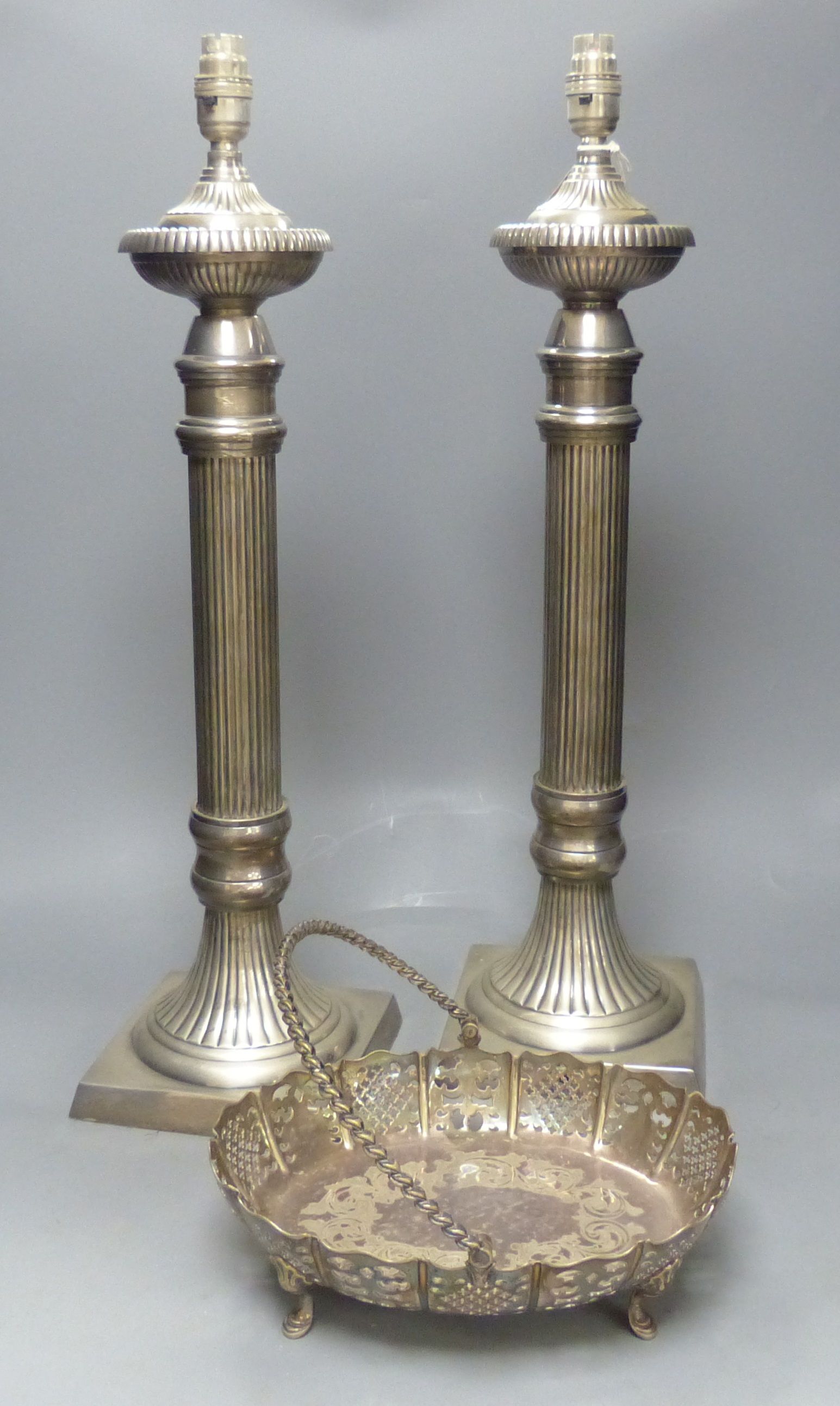 A pair of large plated electric table lamps, each square base marked AWEP, and a plated cake basket